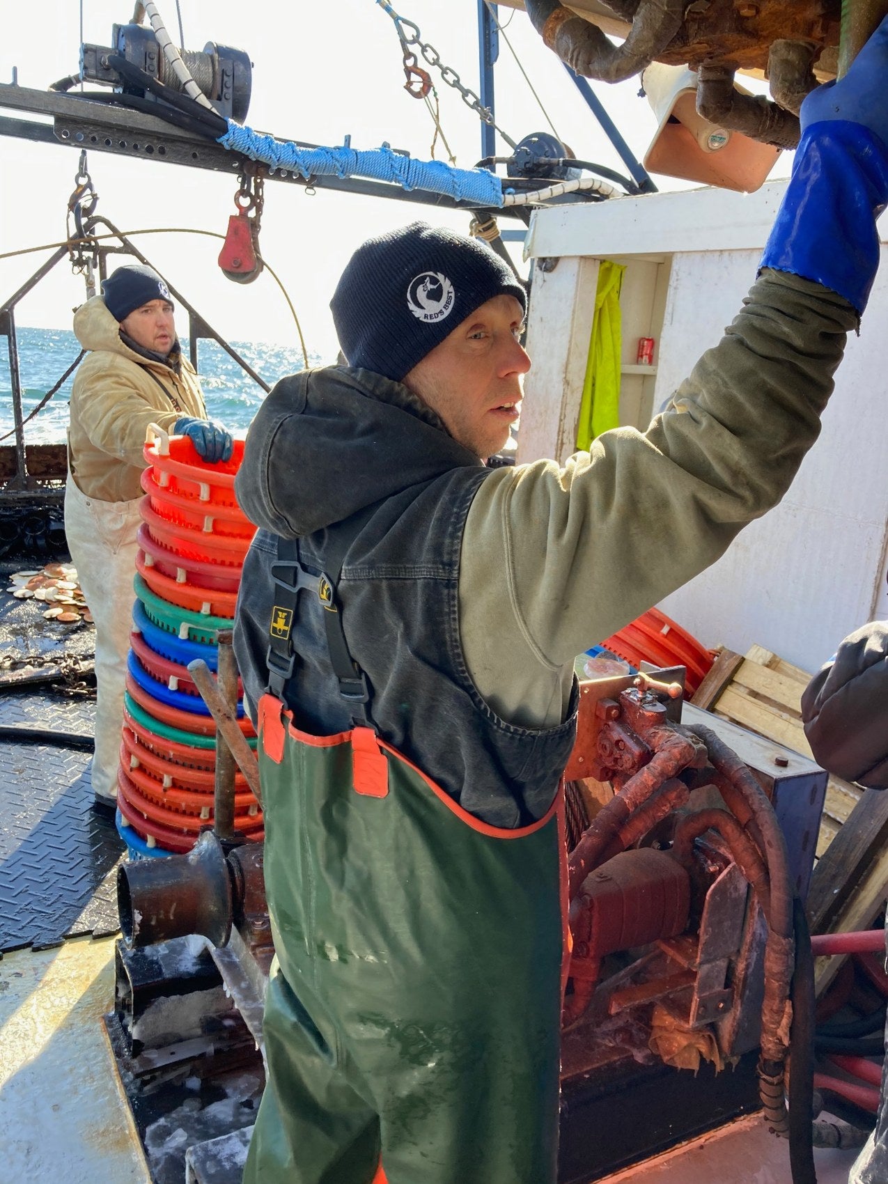 A fisherman wearing a Red’s Best hat working aboard a fishing boat